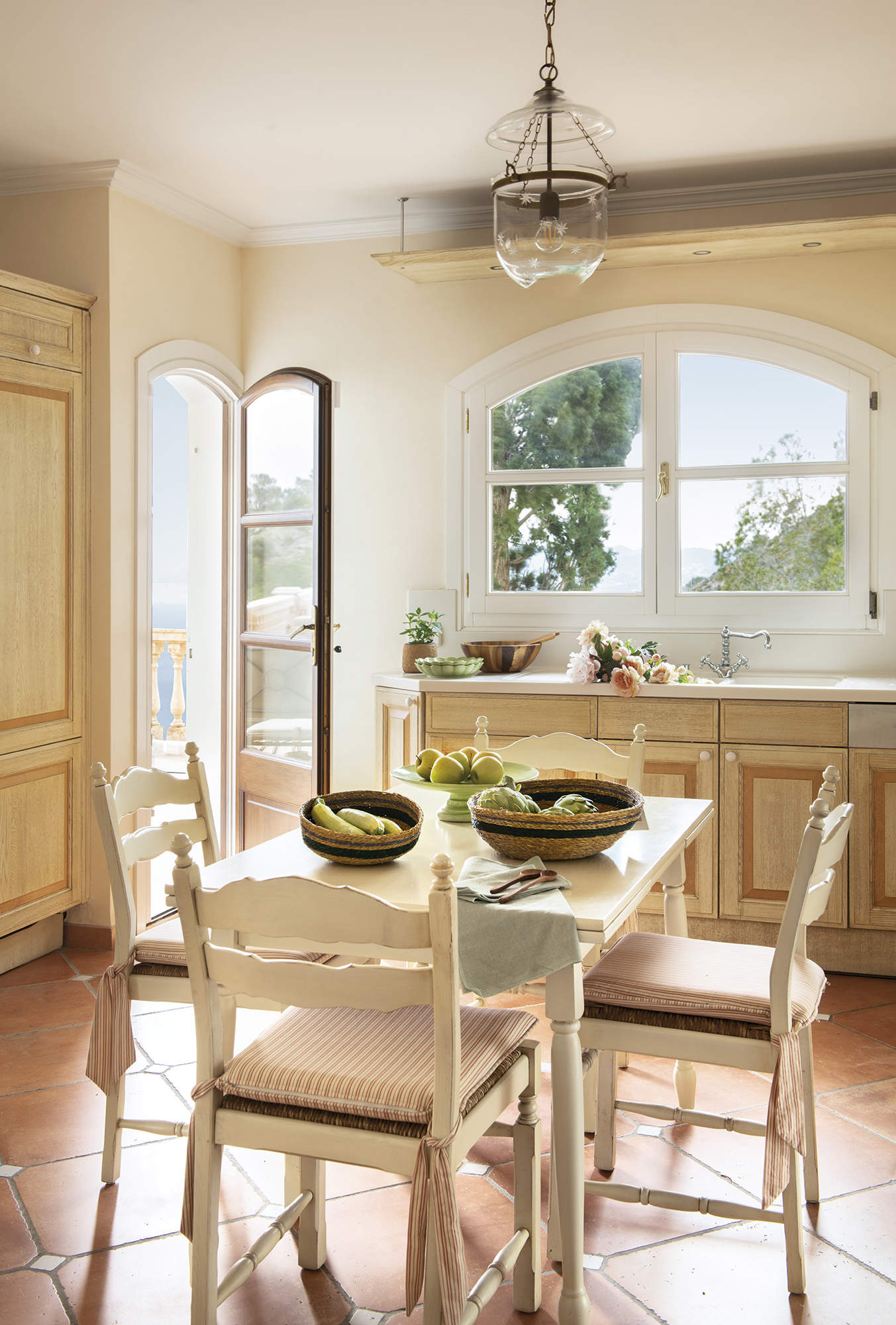cocina con office, mesa y sillas de madera pintada de blanco